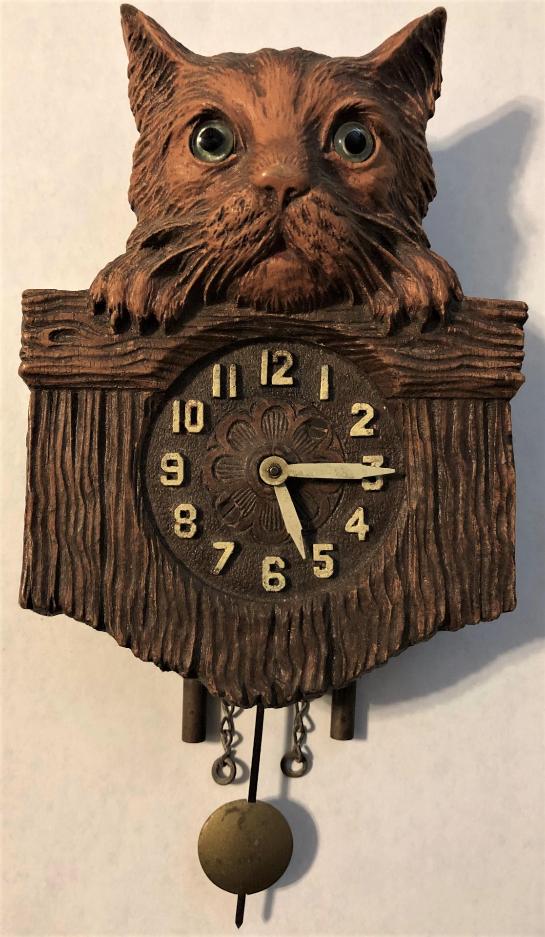 LUX BROWN KITTY CAT PENDULETTE WALL CLOCK: LUX BROWN KITTY CAT W/ GLASS EYES, PEEKING OVER FENCE PENDULETTE WALL CLOCK - NO. 335 CIRCA 1931 - 3 3/4" X 7"