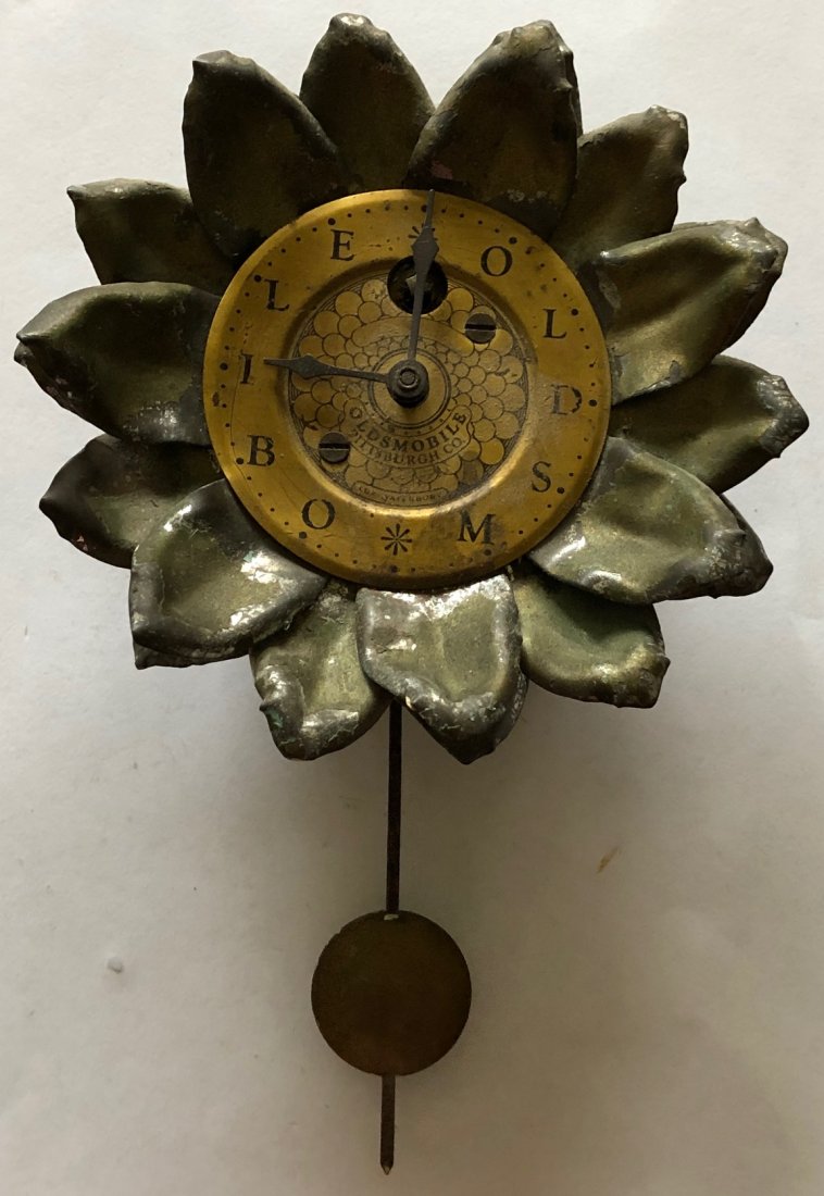LUX 'OLDSMOBILE' SUNFLOWER PENDULETTE WALL CLOCK: RARE EXAMPLE…INSTEAD OF NUMBERS ON CLOCK IT READS "OLDSMOBILE" "OLDSMOBILE PITTSBURGH CO." THE LUX CLOCK MFG. CO. WATERBURY CONN. U.S.A. - NO. 329 - CIRCA 1930 - 6" HIGH X 3 3/4" WIDE