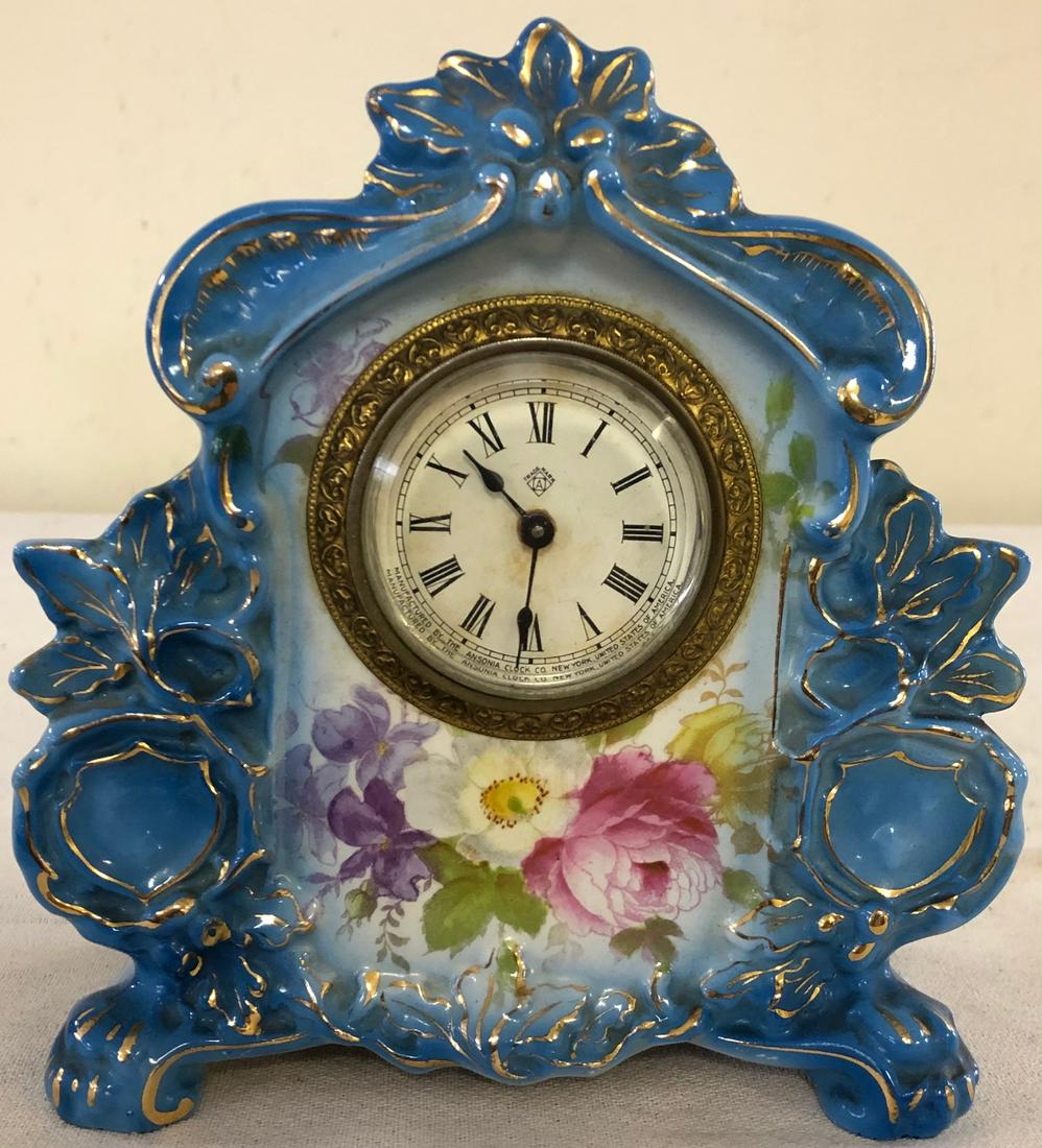 MINIATURE GERMAN ROYAL BONN PORCELAIN SHELF CLOCK: GERMAN "GAZELLE" PATTERN ROYAL BONN CLOCK MARKED ON BACK WITH ROYAL BONN LOGO - IMPRESSED #275 - BLUE WITH GILT HIGHLIGHTS AND FLORAL DECORATION - WORKING WHEN TESTED - NO CHIPS, CRACKS OR REPAIRS - 6