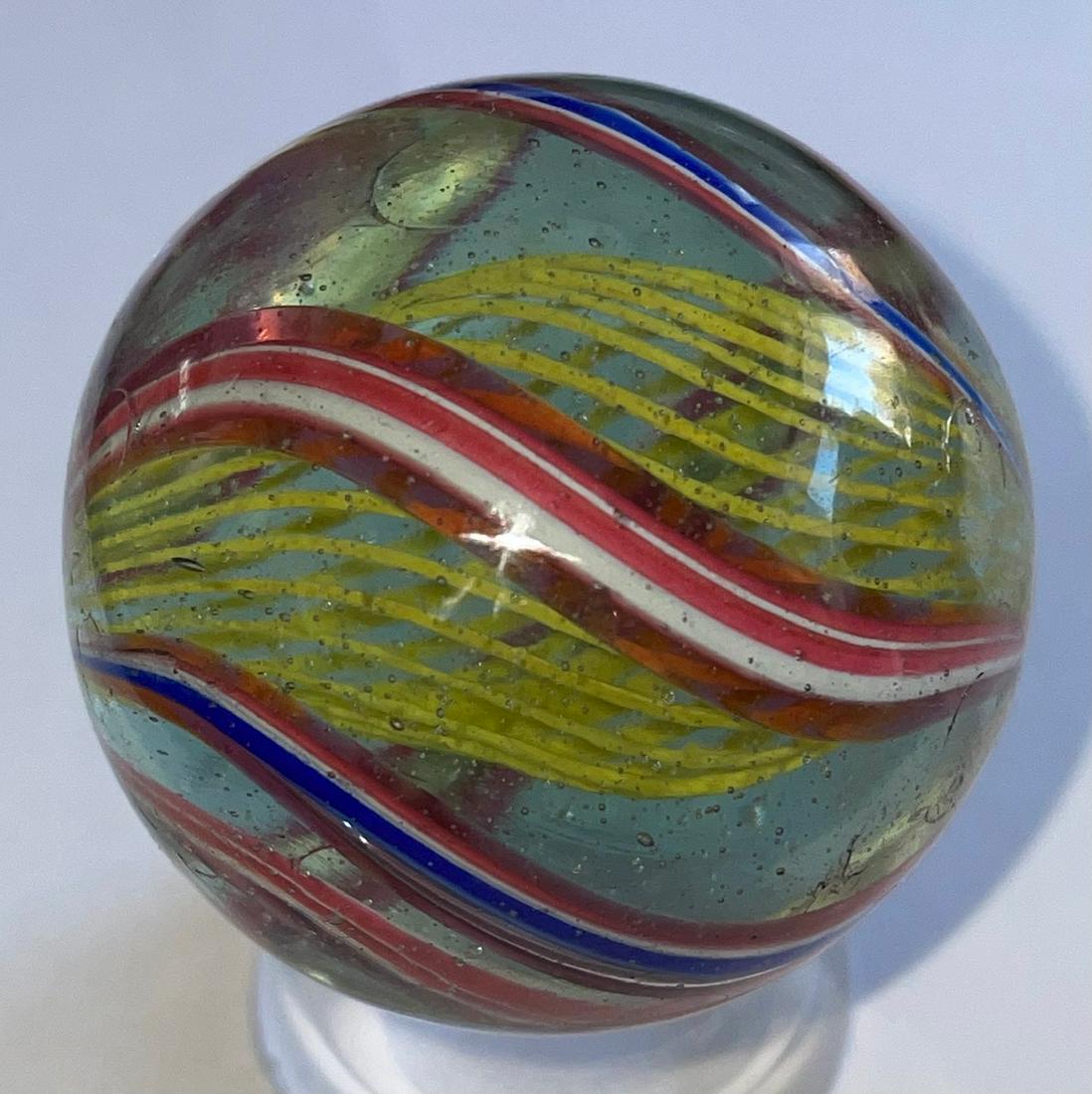 LG 1 5/8" ANTIQUE GERMAN SWIRL LATTICINIO CORE MARBLE: WITH VARIOUS RED, WHITE, BLUE AND GREEN OUTER SWIRLS WITH A YELLOW LATTICINIO CORE - 1 5/8" DIAMETER - MINOR SURFACE WEARâ€¦SEE PHOTOS
