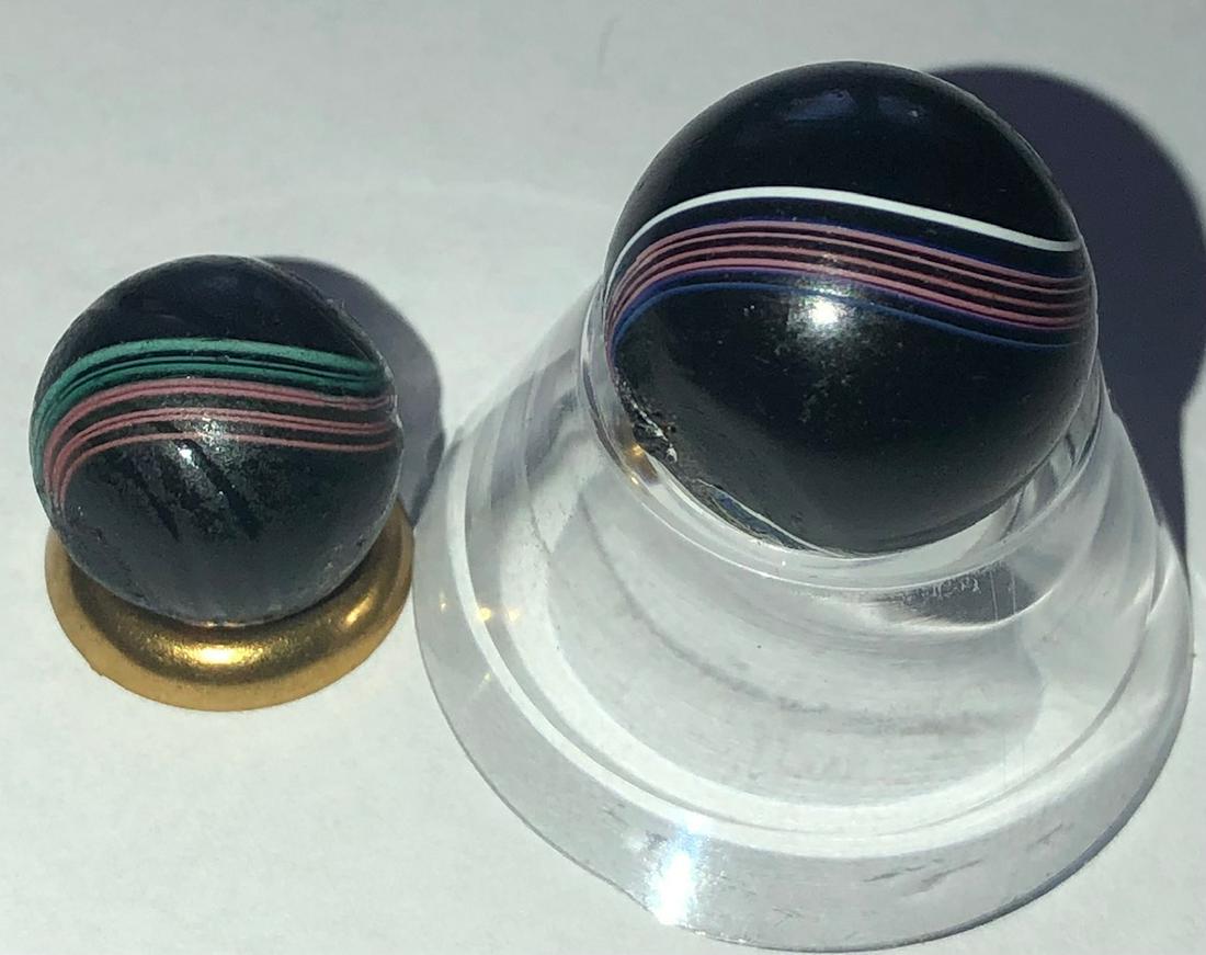 LOT 2 ANTIQUE GERMAN BANDED INDIAN SWIRL MARBLES: LOT 2 ANTIQUE GERMAN BANDED INDIAN SWIRL MARBLES - 1/2" WITH PINK (RED), GREEN & BLUE BANDS, 5/8" WITH PINK (RED), BLUE, YELLOW & WHITE BANDS - BOTH IN VERY GOOD CONDITION WITH MINOR SURFACE WEAR