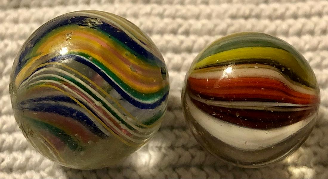LOT 2 ANTIQUE GERMAN SWIRL MARBLES: LOT 2 ANTIQUE GERMAN SWIRL MARBLES - 1. 11/16" DOUBLE WIDE RIBBON CORE IN BLUE, GREEN, ORANGE, YELLOW, TURQUOISE, PINK & WHITE WITH YELLOW & WHITE OUTER LATTICINIO TYPE SWIRLS - 2. 9/16" MULTI-COLOR S