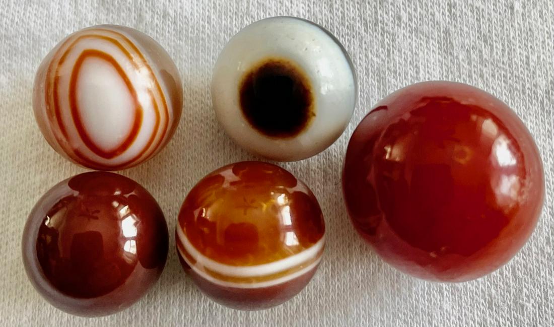 LOT 5 VINTAGE NATURAL BANDED AGATE MARBLES: LOT 5 VINTAGE NATURAL BANDED AGATE MARBLES - ONE WITH AN 'EYEBALL' DESIGN AND 2 OTHERS WITH DECORATIVE CONCENTRIC BANDS - 11/32" - 21/32"