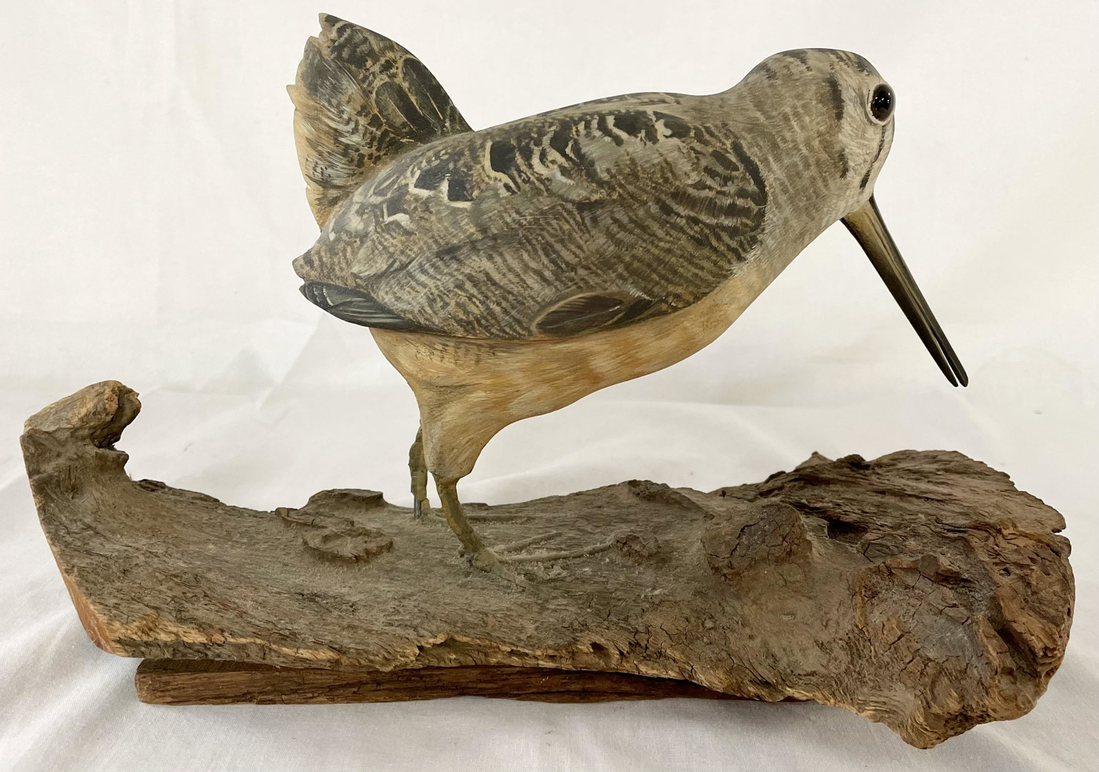 CARVED AND PAINTED WOODCOCK DECOY: CARVED AND PAINTED WOODCOCK DECOY - GLASS EYES, MOUNTED ON DRIFTWOOD -GOOD OVERALL CONDITION - 12 1/2" X 6 3/4" WIDE X 7 1/2" HIGH