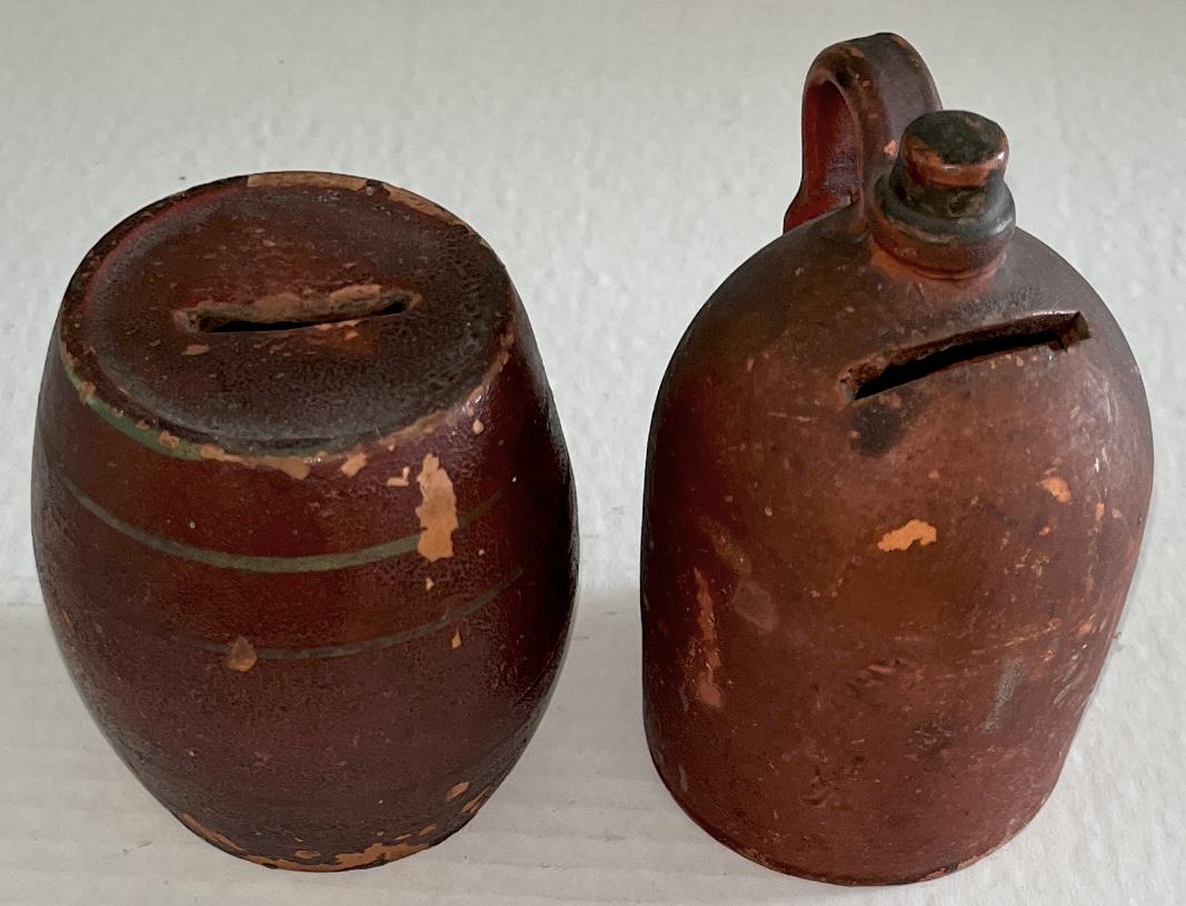 LOT 2 19TH C. REDWARE BANKS: LOT 2 19TH C. REDWARE BANKS - REDWARE BARREL BANK IN ORIGINAL RED PAINT - MINIATURE REDWARE JUG BANK IN ORIGINAL RED PAINT - GOOD OVERALL CONDITION - WEAR TO SURFACES - BARREL 3 3/4" HIGH, 3 1/2" DIAM