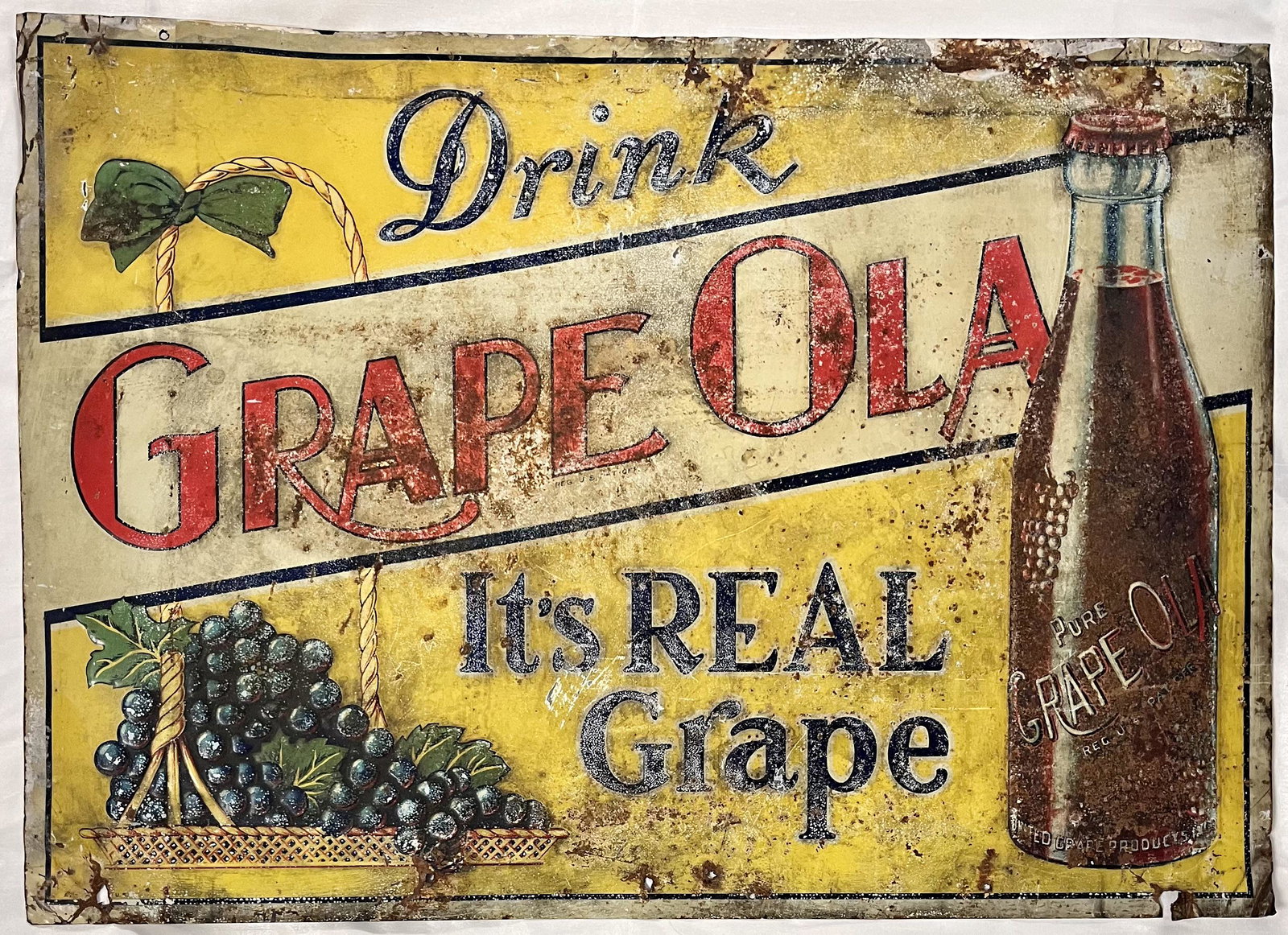 ORIGINAL METAL "DRINK GRAPE OLA" ADVERTISING SIGN: ORIGINAL METAL "DRINK GRAPE OLA" ADVERTISING SIGN - THE SIGN READS "DRINK GRAPE OLA IT'S REAL GRAPE" - CONDITION AS SEEN IN PHOTOS - 27 3/4" X 19 1/2"