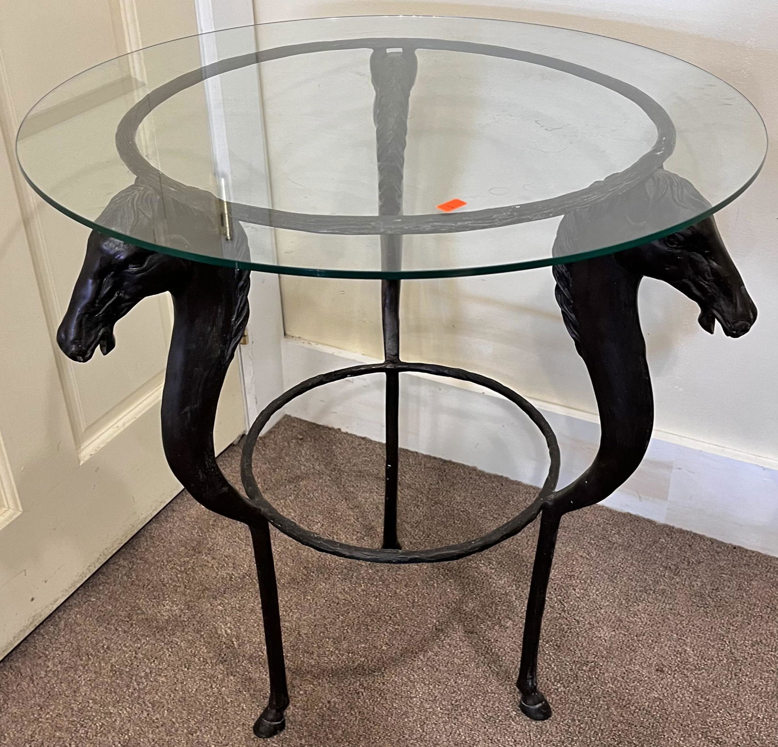 VINTAGE MODERNIST BRONZE HORSE HEAD GLASS TOP TABLE: VINTAGE MODERNIST BRONZE HORSE HEAD GLASS TOP TABLE - BRONZE BASE WITH 3 FIGURAL HORSE HEADS AND HORSE HOOF FEET - ROUND GLASS TOP - GOOD OVERALL CONDITION - BASE 21" X 26 3/4" HIGH, GLASS TOP 24" DIA