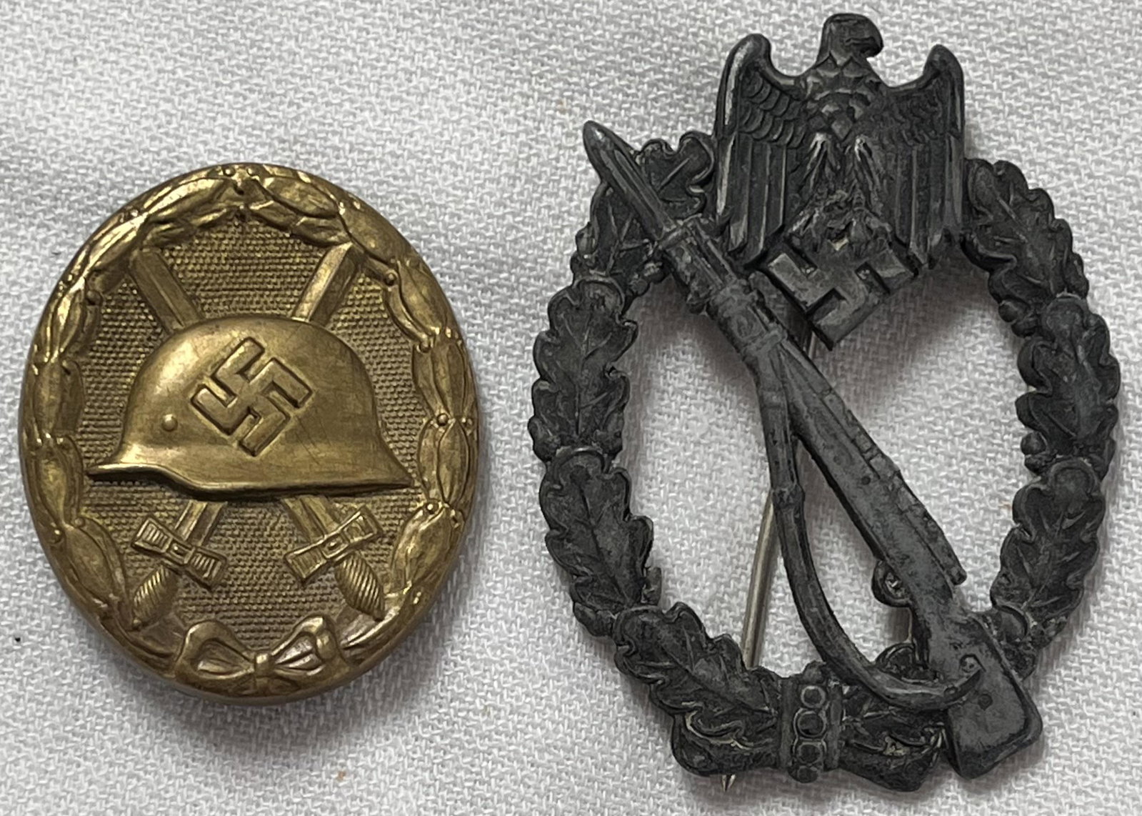 LOT 2 WWII GERMAN NAZI PINS / MEDALS: LOT 2 WWII GERMAN NAZI PINS / MEDALS - OVAL BRASS WITH HELMET, SWORDS 1 3/4" X 1 7/16", WREATH WITH EAGLE & RIFLE 2 1/2" X 1 7/8" BROKEN TIP ON PIN HOLDER ON BACK - FROM SAME BENNINGTON VT. ESTATE AS 