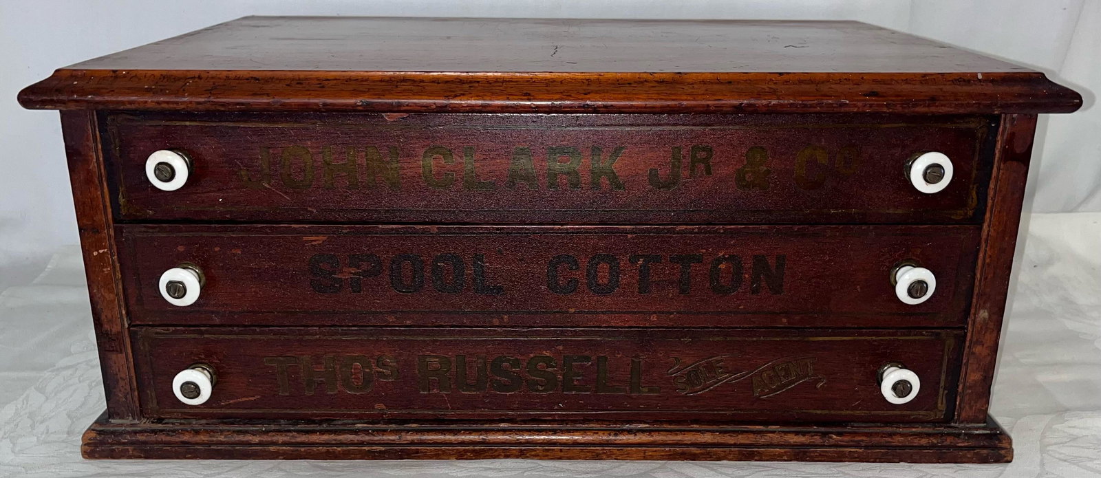 VICTORIAN WALNUT "JOHN CLARK JR." 3 DRAWER SPOOL CABINET: VICTORIAN WALNUT "JOHN CLARK JR. AND CO. SPOOL COTTON / THOS. RUSSEL SOLE AGENT" 3 DRAWER SPOOL CABINET - ORIGINAL WHITE PROCELAIN KNOBS - GOOD CLEAN CONDITION - 22 1/2" WIDE X 15 1/4" DEEP X 9 1/4" H