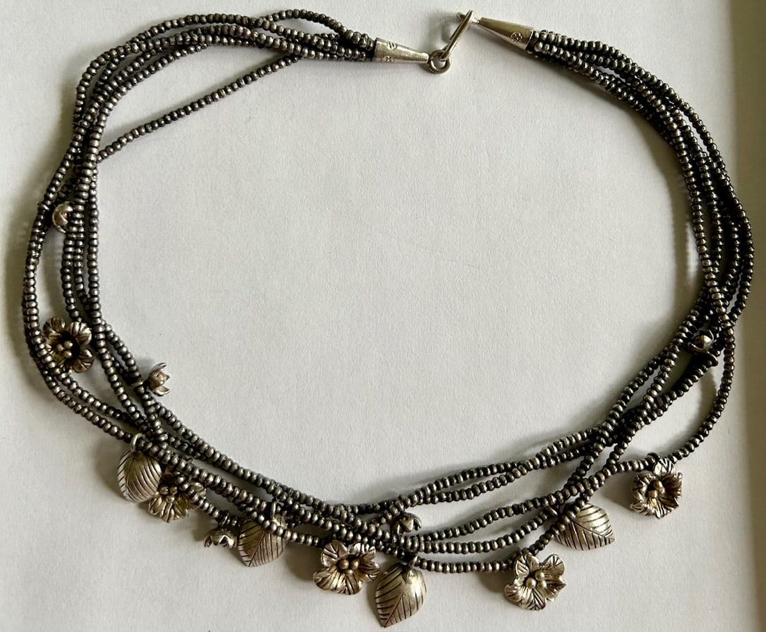 STERLING SILVER NATIVE AMERICAN BEADED CHARM NECKLACE - 59.93 GRAMS: STERLING SILVER NATIVE AMERICAN BEADED CHARM NECKLACE - 59.93 GRAMS - 5 STRANDS OF BEADS WITH 14 FLOWER / LEAF CHARMS - CONE SHAPED CATCH - 17 1/4" LONG