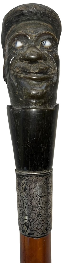 WONDERFUL FOLK ART CANE WITH WONDERFUL CARVED HORN PORTRAIT HANDLE: FOLK ART CANE WITH WONDERFUL CARVED HORN PORTRAIT HANDLE OF A GENTLEMAN WITH GLASS EYES AND CAP (HAT) - ENGRAVED STERLING FERRULE WITH HALL MARKS - APPROX. 37" LONG