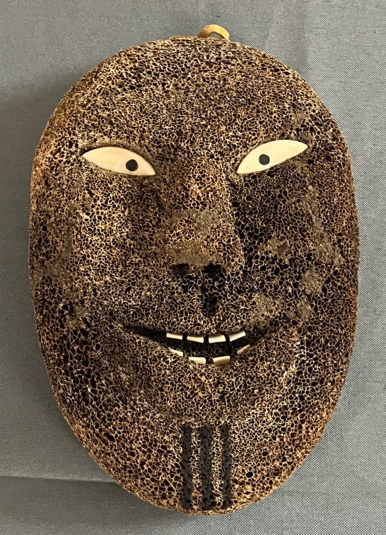 ARCTIC PEOPLES INUIT CARVED FOSSILIZED WHALE BONE MASK: CARVED FOSSILIZED WHALE BONE INUIT ESKIMO MASK WITH CARVED BONE EYES & TEETH, MEASURES APPROX. 8" HIGH X 5 1/2" WIDE, GOOD OVERALL CONDITION, CONDITION AS SEEN IN PHOTOS PROVIDED