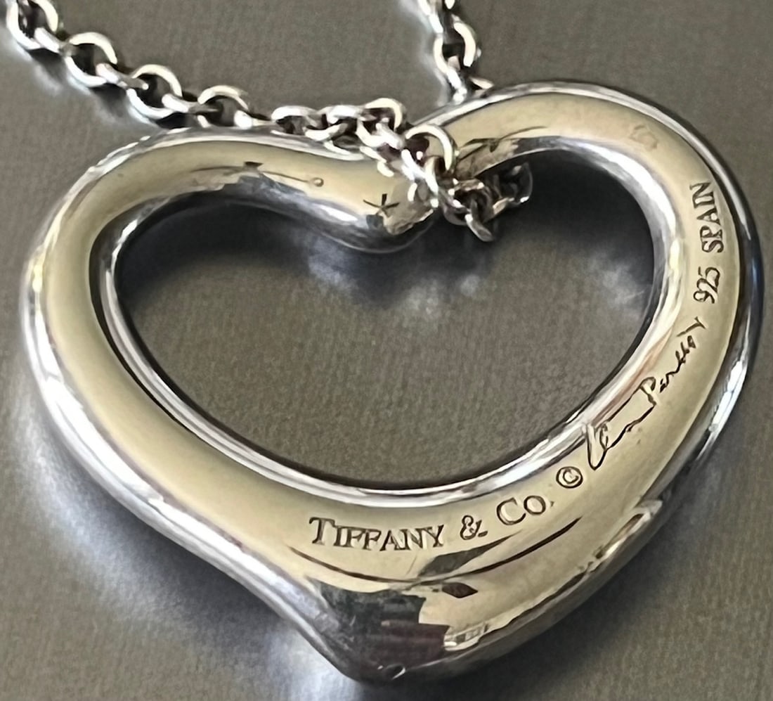 Authentic Tiffany & Co. Elsa Peretti Sterling Silver Open Heart Pendant Necklace, Spain .925: This is an authentic Tiffany & Co. necklace featuring the iconic Elsa Peretti open heart pendant design. Crafted in sterling silver (.925) and made in Spain, this timeless piece features Peretti's ele