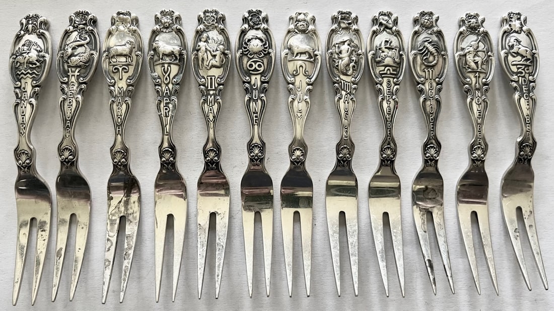 Set of 12 Sterling Silver Zodiac cocktail forks with embossed month, Zodiac symbol & flower, 157.31g: Set of 12 Sterling Silver Zodiac cocktail forks with embossed month, Zodiac symbol & floral decoration, All embossed on reverse with "Sterling", "Pat. Oct. 9.1894" and maker's marks, total weight 157.