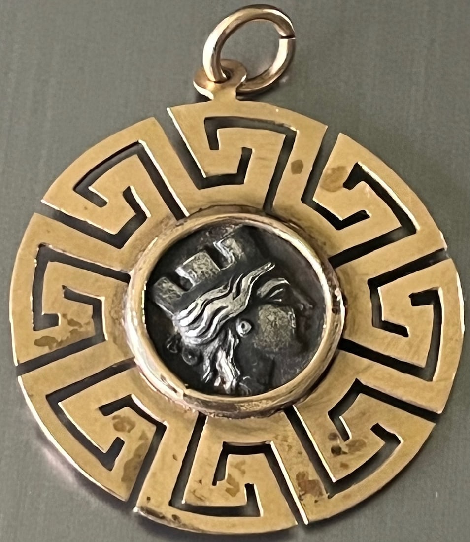 18k yellow gold pendant featuring Ancient Greek Revival Coin in Greek Key Motif Setting, 5.26 g: 18k yellow gold pendant featuring Ancient Greek Revival two-sided silver Coin (or replica) featuring an ancient Greek style helmeted figure in profile on one side, and a trireme (ancient ship) with Gr