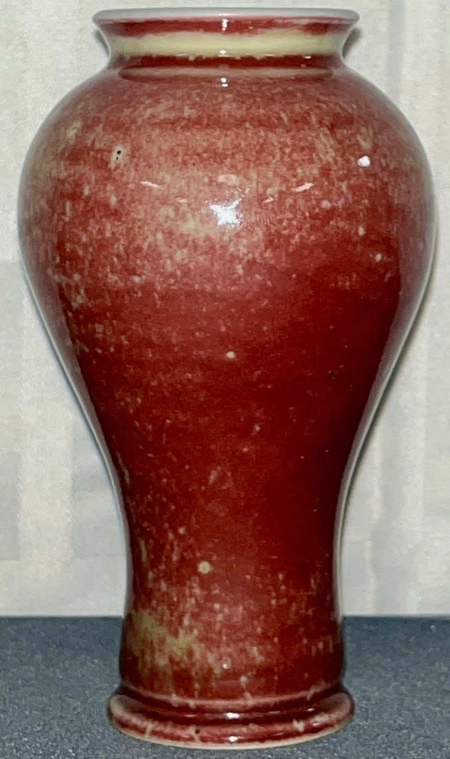 Chinese Flambe Glazed Porcelain Baluster Vase with 6 character Kangxi Reign Mark: A Chinese porcelain vase of baluster form, covered in a flambe oxblood glaze with mottled splashes of yellow / beige tones, exhibiting a high-gloss finish. The underside bears a six character Kangxi r