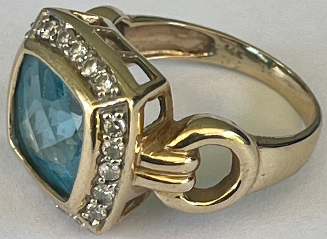 14K Yellow Gold, Diamond, Blue Topaz Ring, Stamped 14K, 7.61 grams: 14K Yellow Gold, Diamond, Blue Topaz Ring, Stamped 14K, 7.61 grams, A large faceted blue topaz surrounded by 20 round-cut diamonds, set in 14K Yellow gold, Size 7.5 / 8, weight 7.61 grams all inclusiv