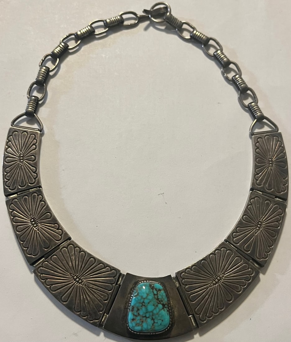 Vintage Navajo Sterling Silver & Turquoise Collar Necklace, Tommy Singer Workshop, 104.5 grams: Vintage Navajo Sterling Silver & Turquoise Collar-style Necklace featuring heavy hand-tooled sterling silver links with stamped sunrise or blossom motifs, a central bezel-set natural turquoise cabocho