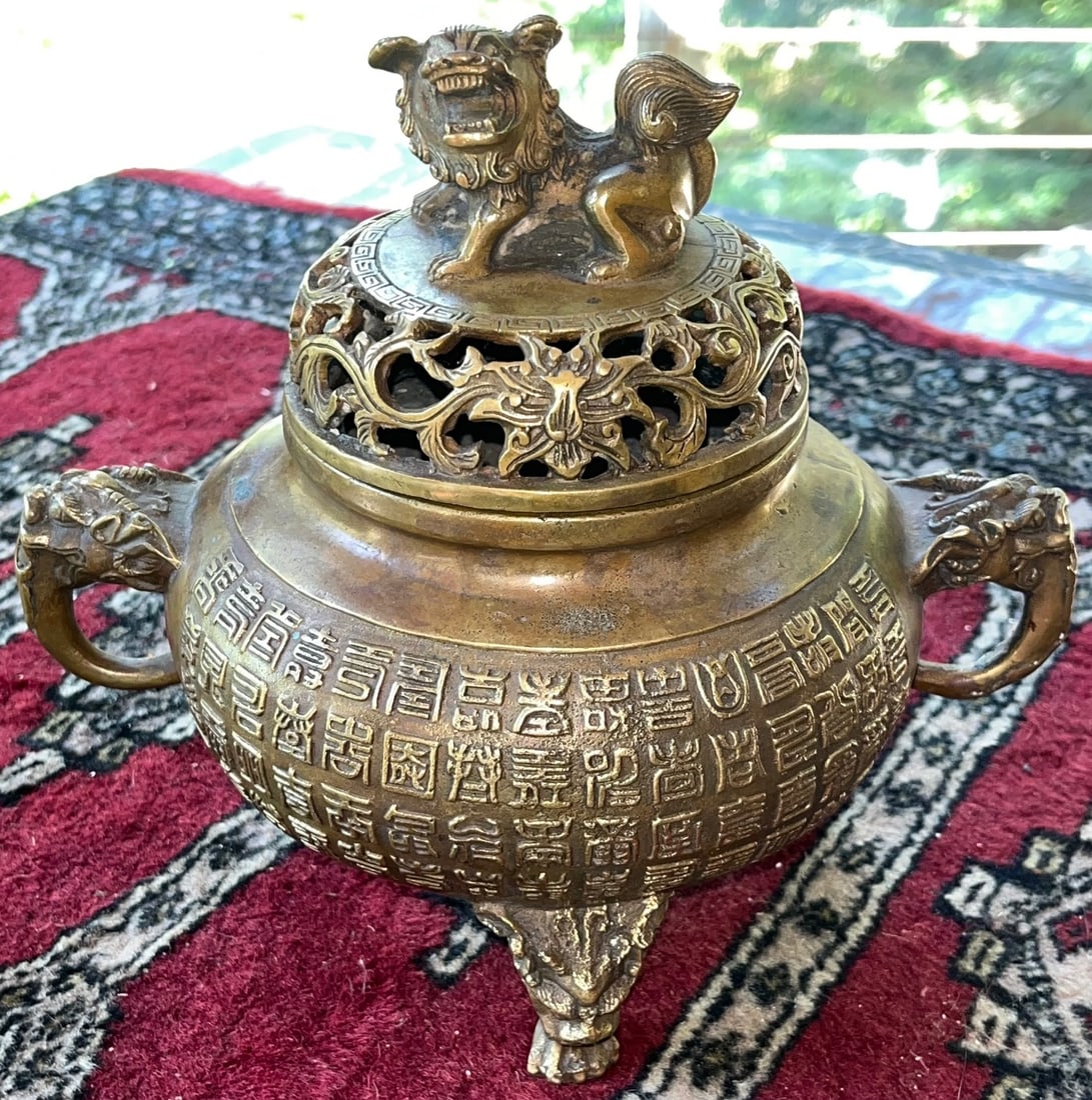Chinese Archaistic Bronze Tripod Censer with Foo Dog Finial, Qianlong Mark: Chinese Archaistic Bronze Tripod Censer (Incense Burner) with Foo Dog Finial, Qianlong 4 character Mark, Lion or Dragon Head handles and three mask-form feet. Measures approx. 8 1/2" H, 8 1/2" W at ha