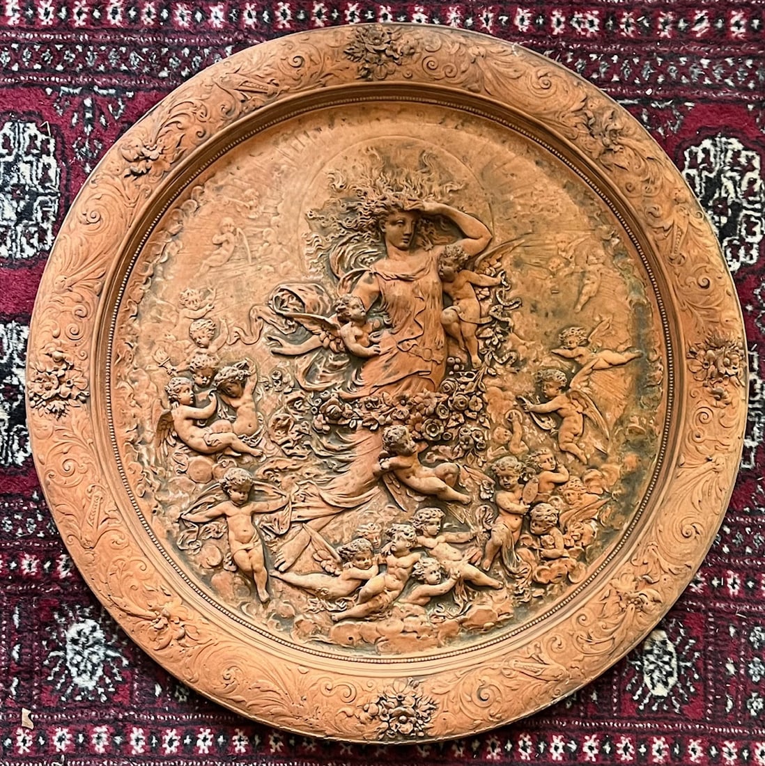 Large Terra Cotta Figural Wall Plaque, Allegorical Female with Putti: Large Round Terra Cotta Figural Wall Plaque, with a high relief Allegorical Female surrounded by cherubs or Putti, among floral garlands and swirling drapery, common during the period of revivalist cl