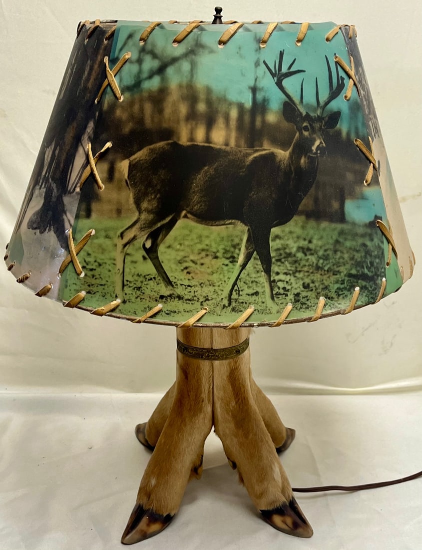 Vintage Taxidermy Deer Hoof Table Lamp w/ Original Laced Buck Scene Shade: Vintage Taxidermy Deer Hoof Table Lamp w/ Original Laced Buck Scene Shade – Working Condition, A striking mid-century rustic cabin lamp featuring a taxidermy deer hoof base and its original parchmen