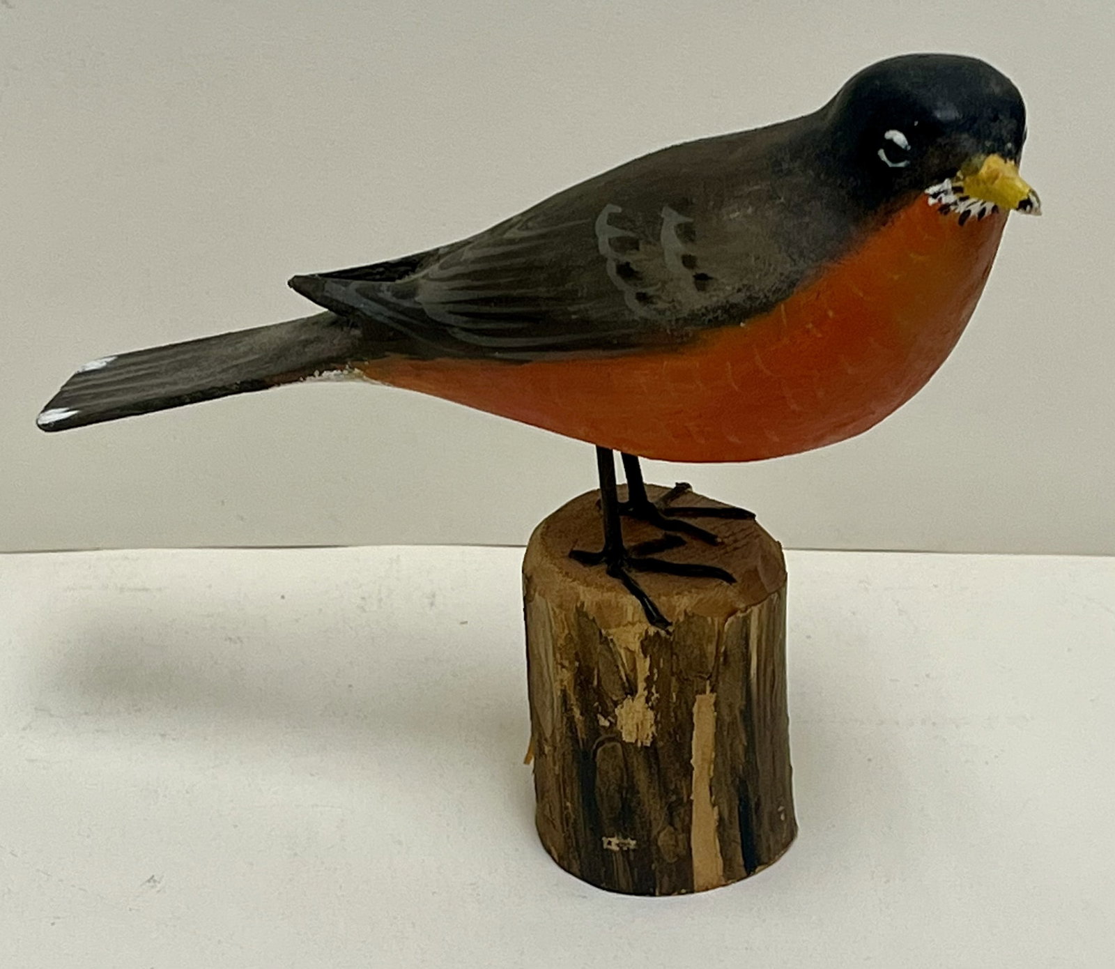 Peter Peltz Folk Art Hand-Carved & Painted Robin Bird Sculpture on Log Base, Signed: Hand-carved and hand-painted folk art bird sculpture by noted folk artist Peter Peltz, depicting an American robin perched on a carved log base. The bird is rendered in a classic naïve folk style wit