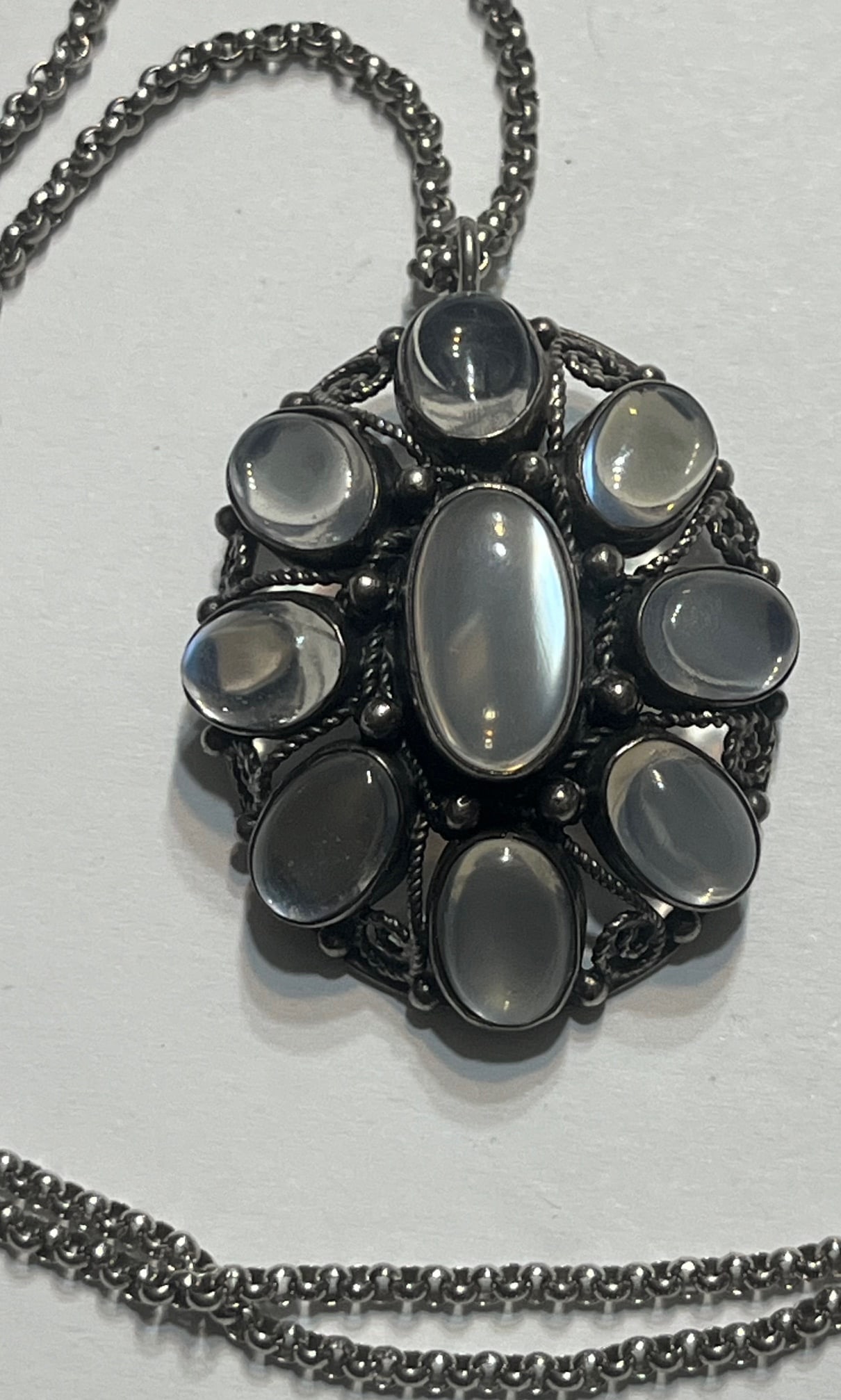 Vintage Sterling Silver Moonstone Cluster Pendant Necklace – 925 – Artisan Filigree – 19g: 16.91 GRAMS, vintage sterling silver moonstone pendant necklace, featuring a large central oval moonstone surrounded by a halo of eight matching oval cabochon moonstones. The stones display a soft blu