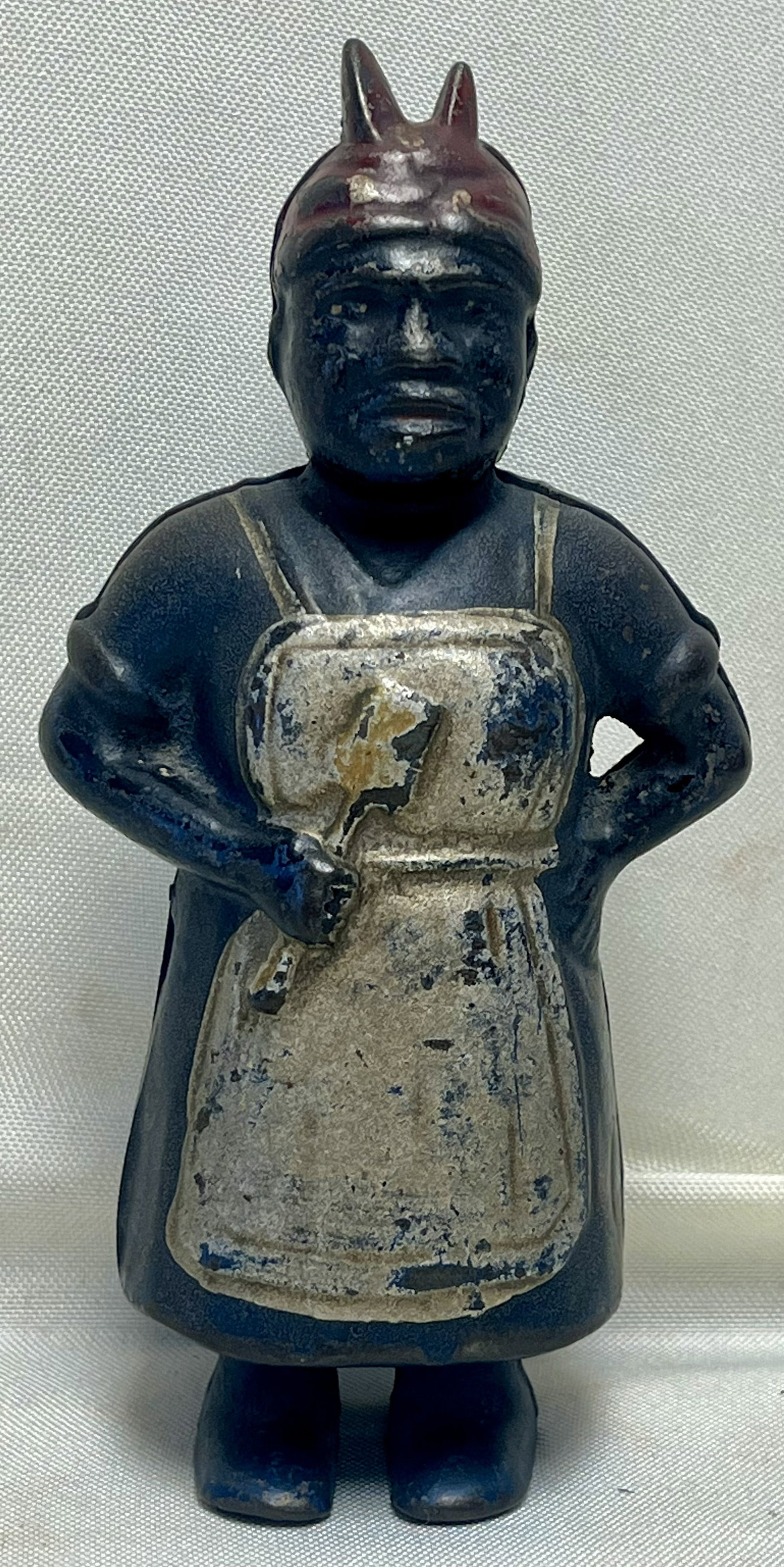 Antique Cast Iron Aunt Jemima Still Bank with Apron, Original Paint, c. 1900–1920: Antique Cast Iron Aunt Jemima Still Bank with Apron, Original Paint, c. 1900–1920, The figural bank depicts Aunt Jemima wearing a headscarf with molded knot, long dress, and apron, standing with rig