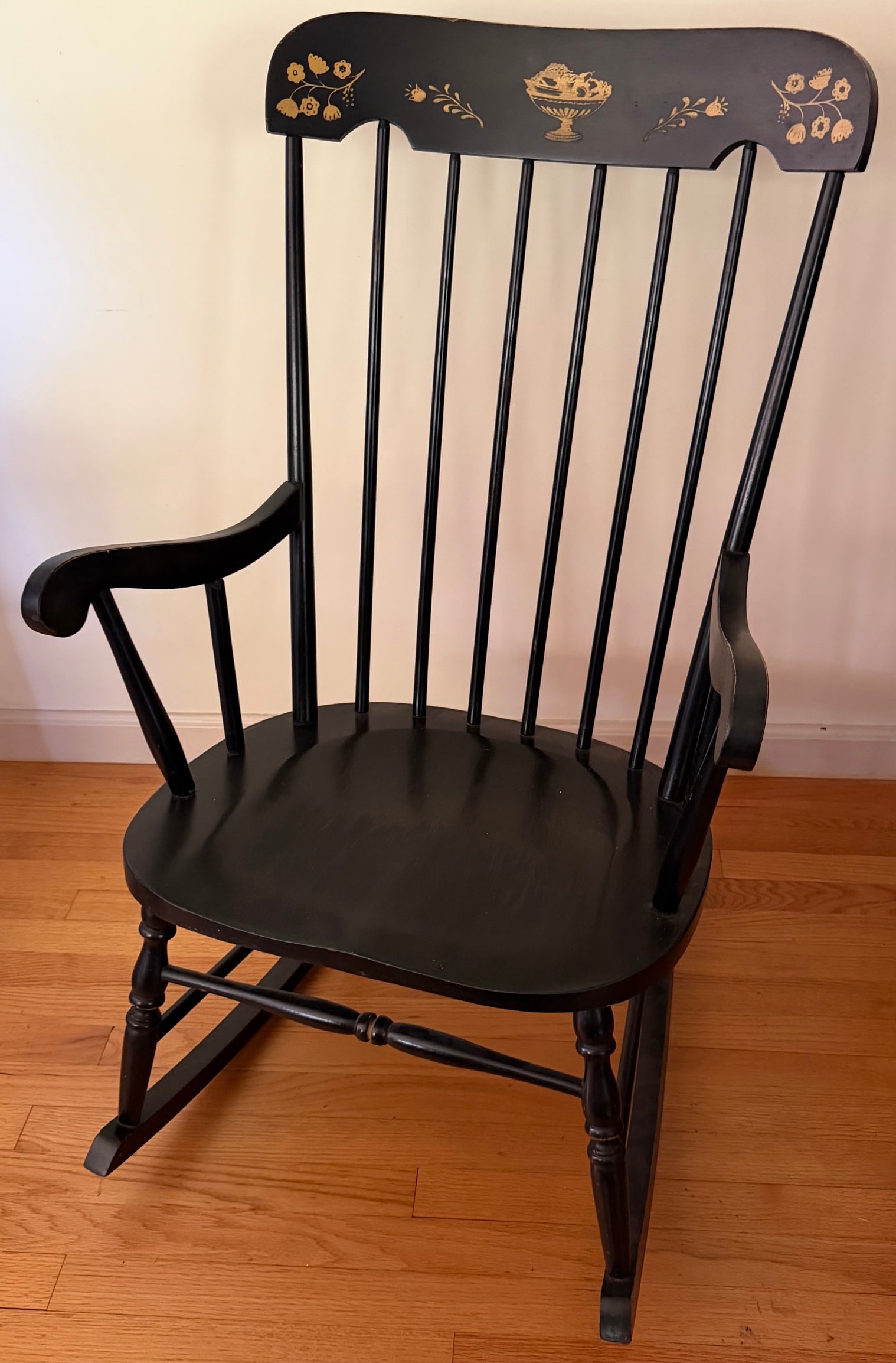 Vintage American Black Painted & Gilt Decorated Rocking Chair: Vintage American rocking armchair, constructed in wood and finished in black paint. Features a tall spindle back with shaped crest rail, continuous scrolling arms, shaped plank seat, turned front supp