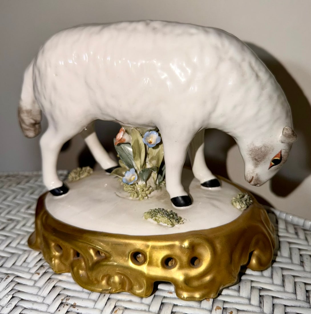 Vintage Mottahedeh Porcelain Grazing Sheep Figure on Gilt Base: Vintage porcelain figure depicting a white sheep or lamb grazing beside a flowering tree stump, modeled with delicately textured fleece, black hooves, painted facial details, and applied blue and yell