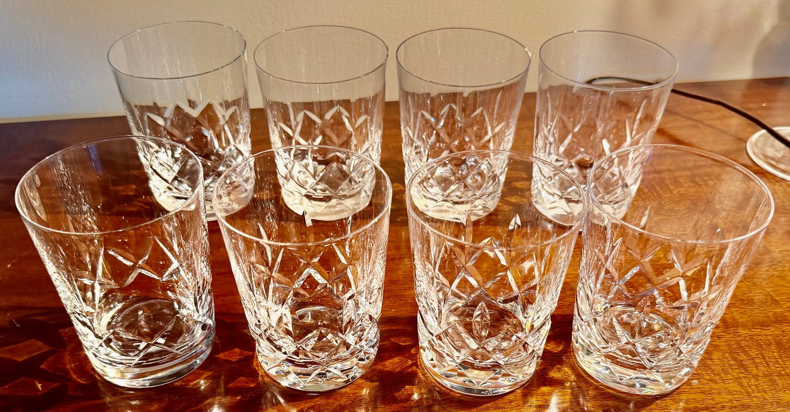 Set of 8 Stuart England Cut Crystal Whiskey Tumblers: Set of eight Stuart Crystal clear cut-crystal drinking glasses, made in England. Each features a traditional geometric cut decoration with intersecting diamonds and elongated pointed cuts rising from 