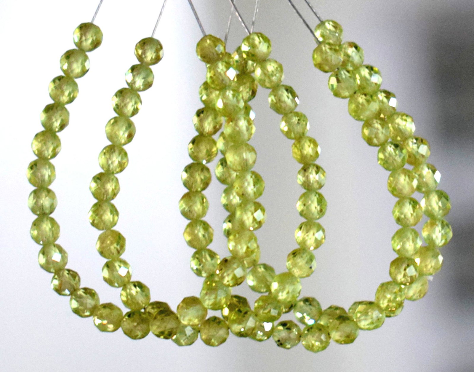 4 TASSEL -NATURAL PERIDOT - ROUND 3.5 MM: TASSEL- means the drilled pieces of gemstones are loosely attached with a wire , ideally you can use it to create of of a kind jewelry . STONE : NATURAL GEM QUALITY PERIDOT FACETED ROUND BEADS . All t