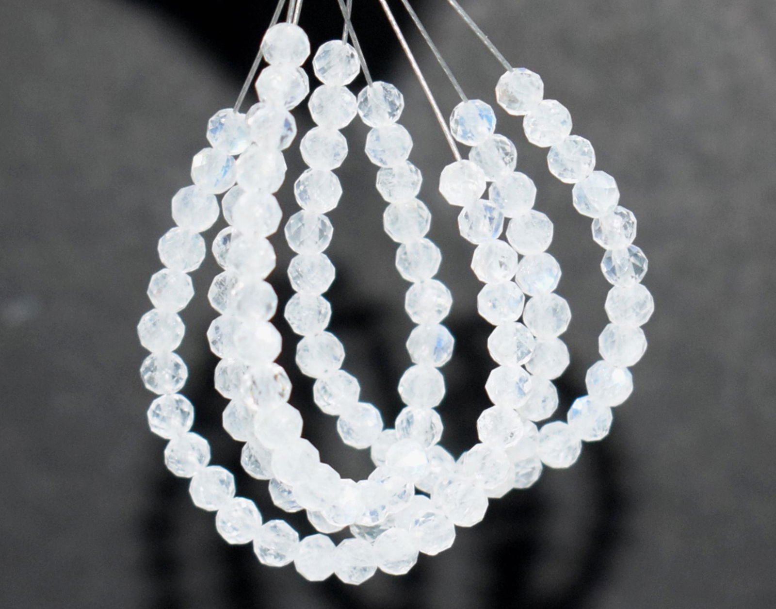 4 TASSEL - RAINBOW MOONSTONE - ROUND 3 MM: TASSEL- means the drilled pieces of gemstones are loosely attached with a wire , ideally you can use it to create of of a kind jewelry . STONE : NATURAL GEM QUALITY RAINBOW MOONSTONE FACETED ROUND BEA