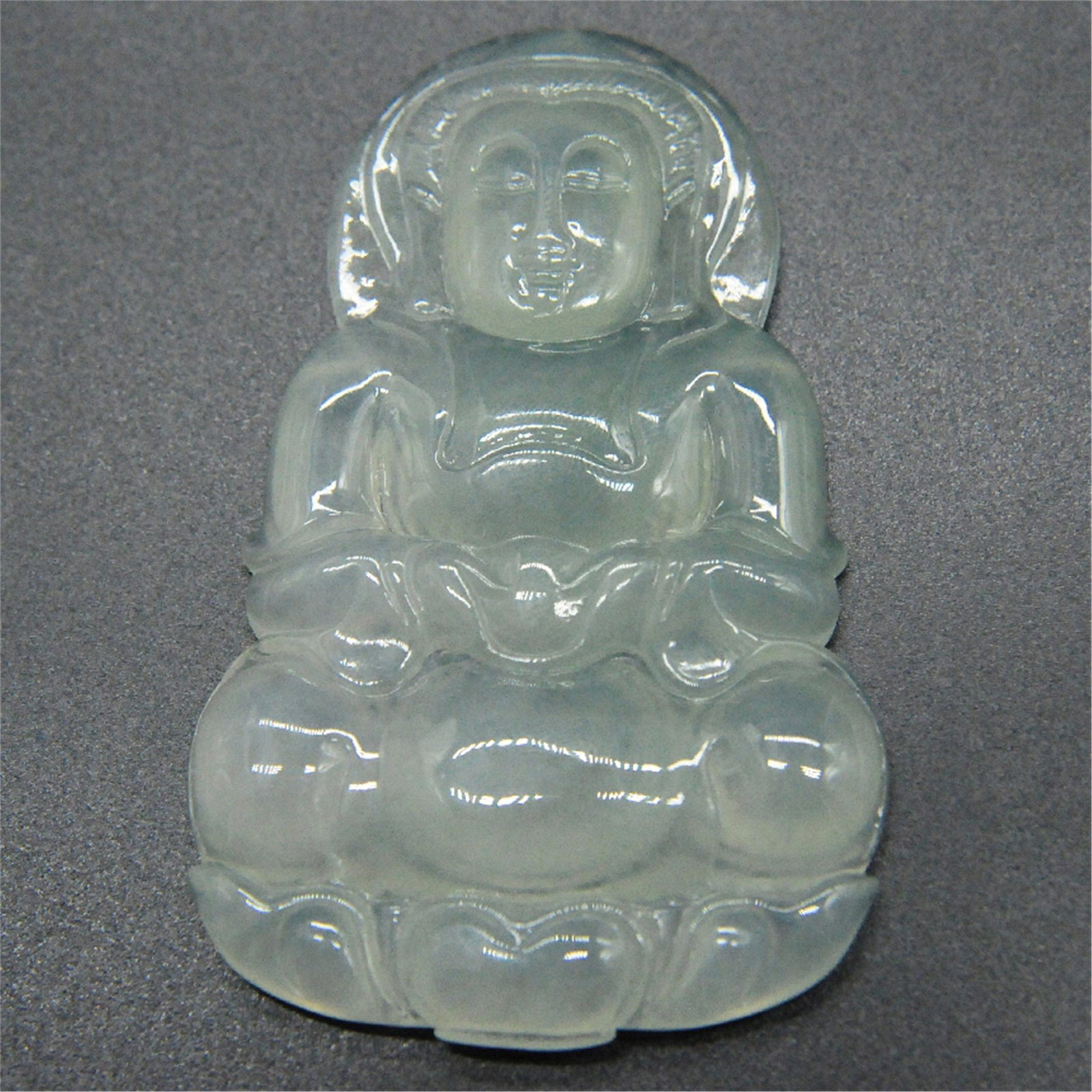 A CHINESE NATURAL JADEITE GUANYIN PENDANT: A CHINESE NATURAL JADEITE GUANYIN PENDANT. L. 6 cm. W. 4 cm. Weight 31.91 gram. Shipping cost $30 to US 48 states and $100 for oversea International delivery. Local pickup at our office available but 