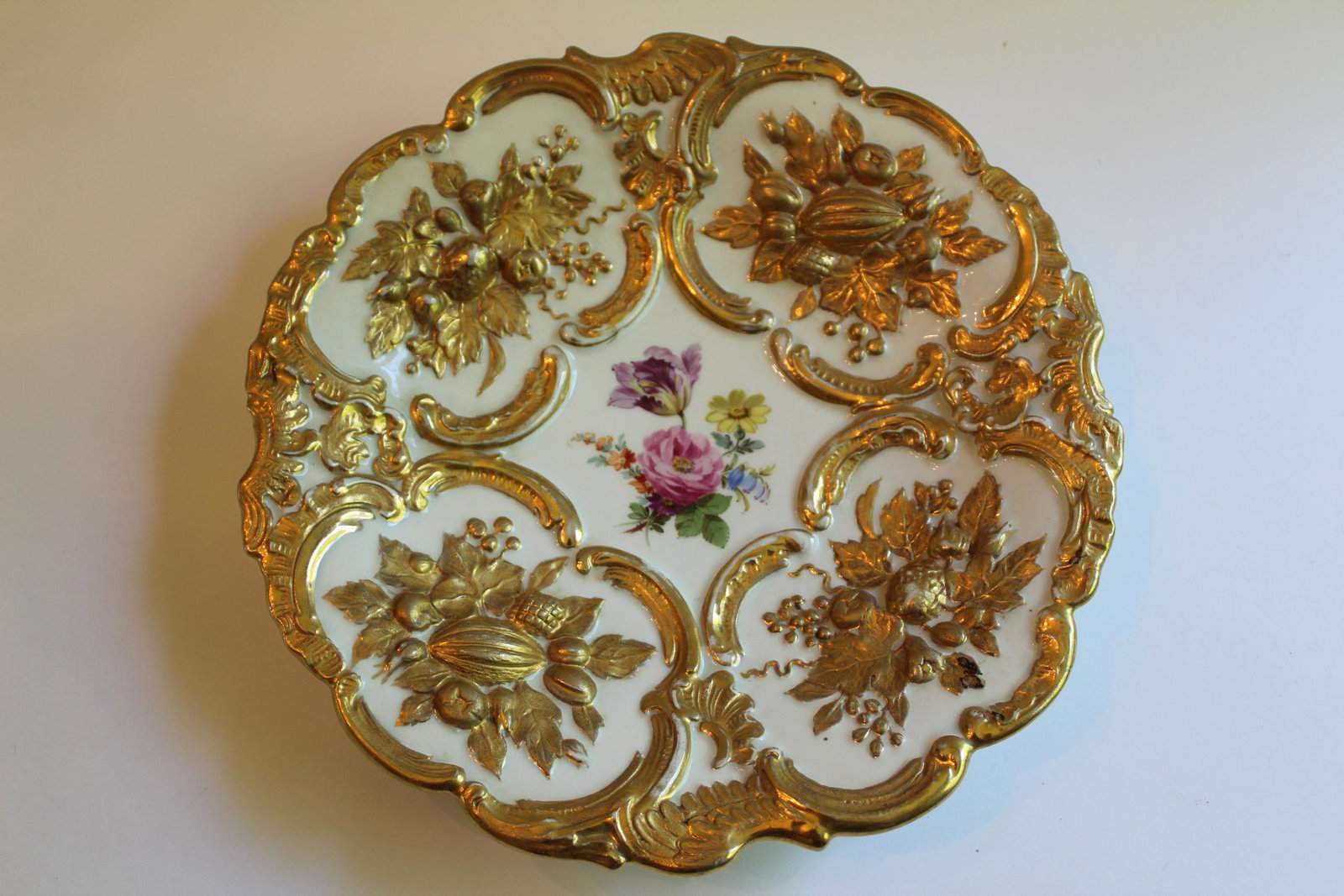 MEISSEN GOLD FRUIT AND FLOWERS PLATE: Meissen plate with raised gold gilded fruits and leaves and painted flowers at the center. D 8.25 inches.