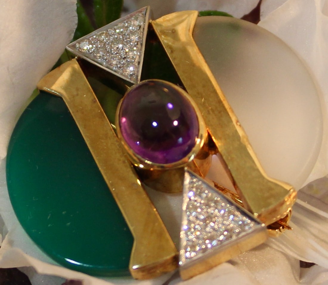 ART DECO DESIGN 18K DIAMOND BROOCH: 18k yellow gold brooch set with diamonds and carved stone semi circles on each end in green and white. Hall marks on the back of brooch.