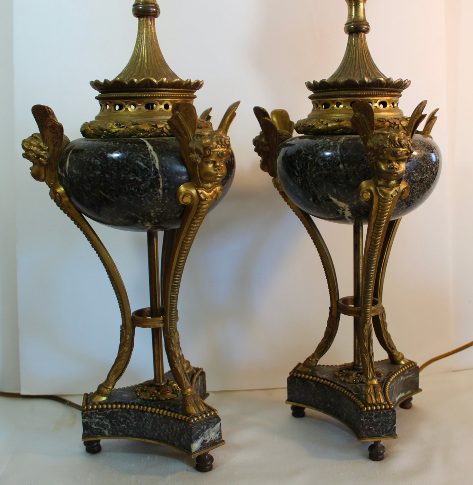 LOUIS XVI GILT BRONZE URNS LAMPS: Fine 19th pair of marble and gold gilt bronze urns now mounted as lamps with angel putti faces and moth wings emanating from below the head in caryatid type mountings. Urn Height 12.5 inches.