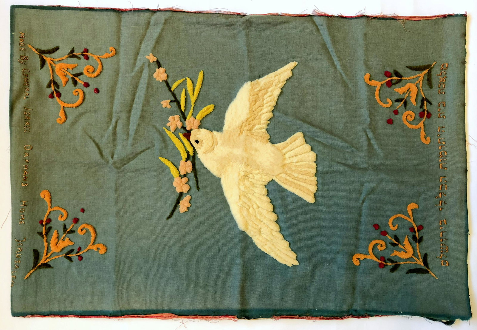 Embroidered Cloth - General Orphans Home in Jerusalem: Embroidery textile cloth made in Jerusalem. On its center, is a white dove carrying a branch in its beak, apparently relating to the biblical story of Noah's Ark. At the four corners are floral and ge