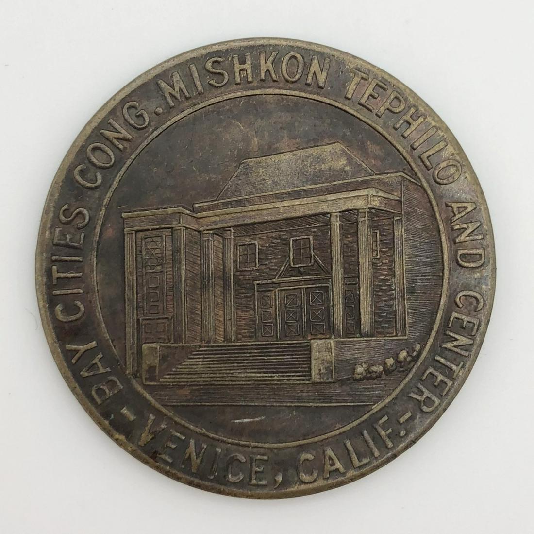 Medal - Mishkon Tephilo Temple - California, 1941: Medal issued by the Mishkon Tephilo congregation in Venice, California, apparently to raise money for building the synagogue, in the midst of WW2. The medal shows the planned synagogue building surrou