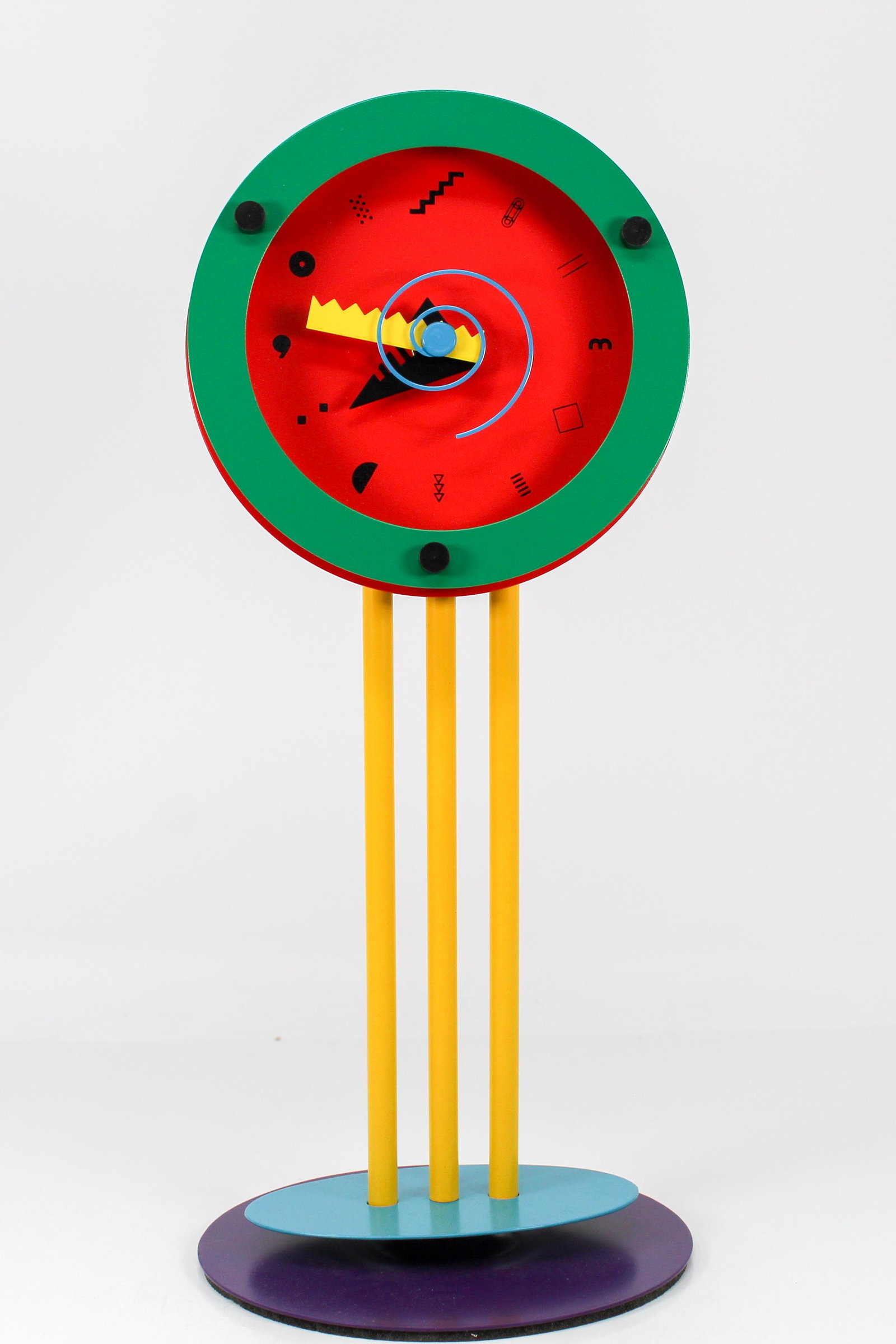 MEMPHIS PARADISE TABLE CLOCK IN BOX (ca. 1985): Designed by Shohei Mihara, enameled steel and enameled aluminum construction, stamped manufacturer's mark on the back, in its original box.
