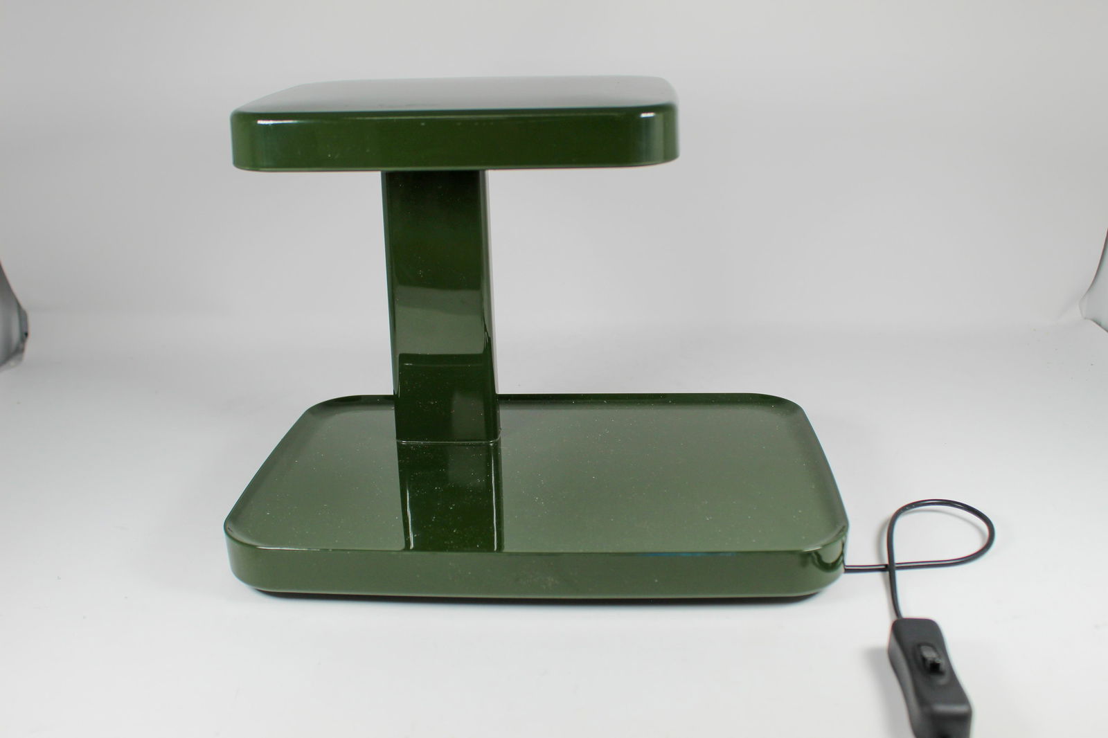 PIANI DESK LAMP: Made by Flos, circa 2011, the flat base is like a stage onto which a triangular beam of light shines down on whateverâ€™s placed on it. Made of and polished and die-cast aluminum with an optical