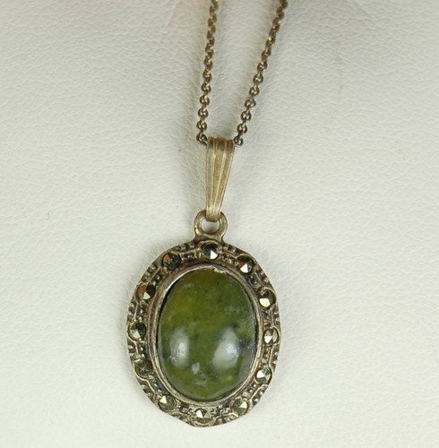 ANTIQUE STERLING NECKLACE JADE MARCASITE PENDANT CHAIN: This ANTIQUE STERLING SILVER Necklace features a Pendant with an Oval Green JADE surrounded by MARCASITES. The Jade Pendant measures 1 inch (with the bail) x 5/8 inch in width. The chain is 18 inches 