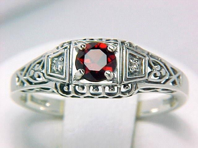 ANTIQUE STERLING SILVER RING GARNET DIAMOND FILIGREE: Vintage Style Sterling Silver ring featuring a round GARNET = .15 Carats, with a DIAMOND set each side. The Garnet and Diamonds are surrounded by exquisite filigree work.