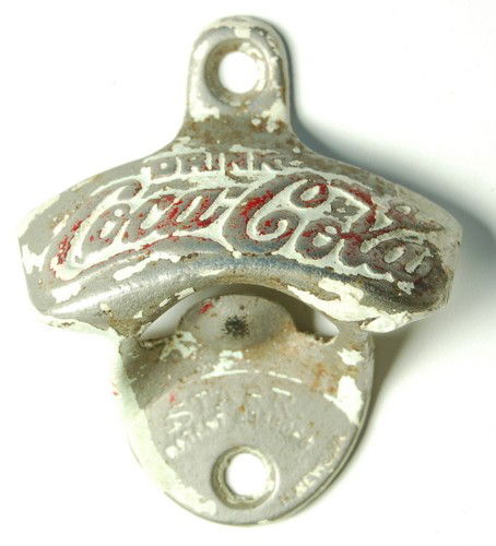 ANTIQUE COCA-COLA WALL MOUNT BOTTLE OPENER: This is an Antique Coca-Cola wall mount bottle opener that came from an old Coke vending machine. The front of it is marked 'Starr' and the back has a '6' on it. It measures 3 1/4" x 3" .