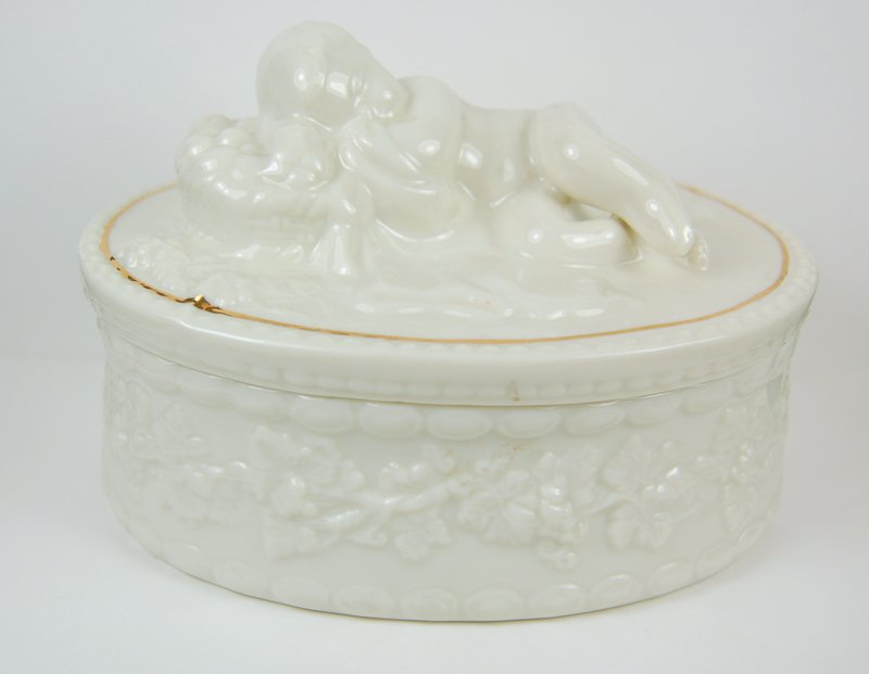 VINTAGE BELLEEK TRINKET BOX PARIAN CHINA CHERUB: BELLEEK made this Trinket Box from Fine Parian China between 1993 and 1998.The oval-shaped box is adorned with a wraparound vine. Its lid features a dreamy Cherub. The lid is outlined in Gold accent. 