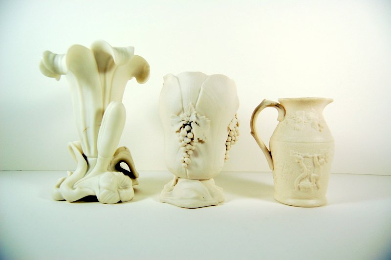 3 ANTIQUE PARIAN WARE CERAMIC PITCHER VASE 1850 (48102): These three Antique Parian Ware Ceramic pieces were made Circa 1850. They include a Ceramic Vase with grape clusters, a Ceramic Vase in the shape of a Flower, and a Pitcher with 3 dimensional figures.