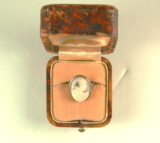 ANTIQUE GOLD RING CAMEO OF WOMAN WITH DIAMOND AT HER: This Antique Ring is Circa 1900. It is 10K Yellow Gold and it features an Oval Cameo of a woman with a DIAMOND in her hair. The Cameo is set within a Gold frame bezel. The ring is a Size 4 3/4 and it