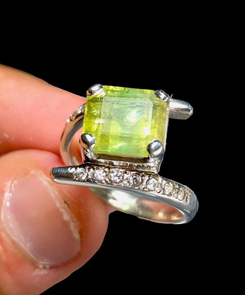 Green Tourmaline Ring With Zircons In Silver: Green Tourmaline Ring With Zircons In Silverstone Weight: 5 CaratsRing Size: 8 US(Adjustable)Ring Weight: 5.88 GramsZircons: 40 CENTS Choose design of your own and we will make it for youWe accept cus
