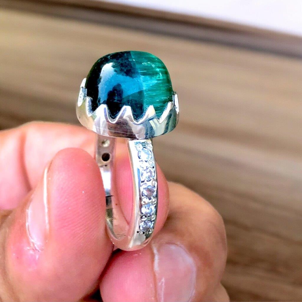 Sterling Silver Bi Color Tourmaline Cab Ring: Sterling Silver Bi Color Tourmaline Cab Ring Stone Weight: 13.45 Carats Ring Size: 9 US (Adjustable)Ring Weight: 7.64 Grams Zircons: 40 Cents Choose design of your own and we will make it for youWe ac