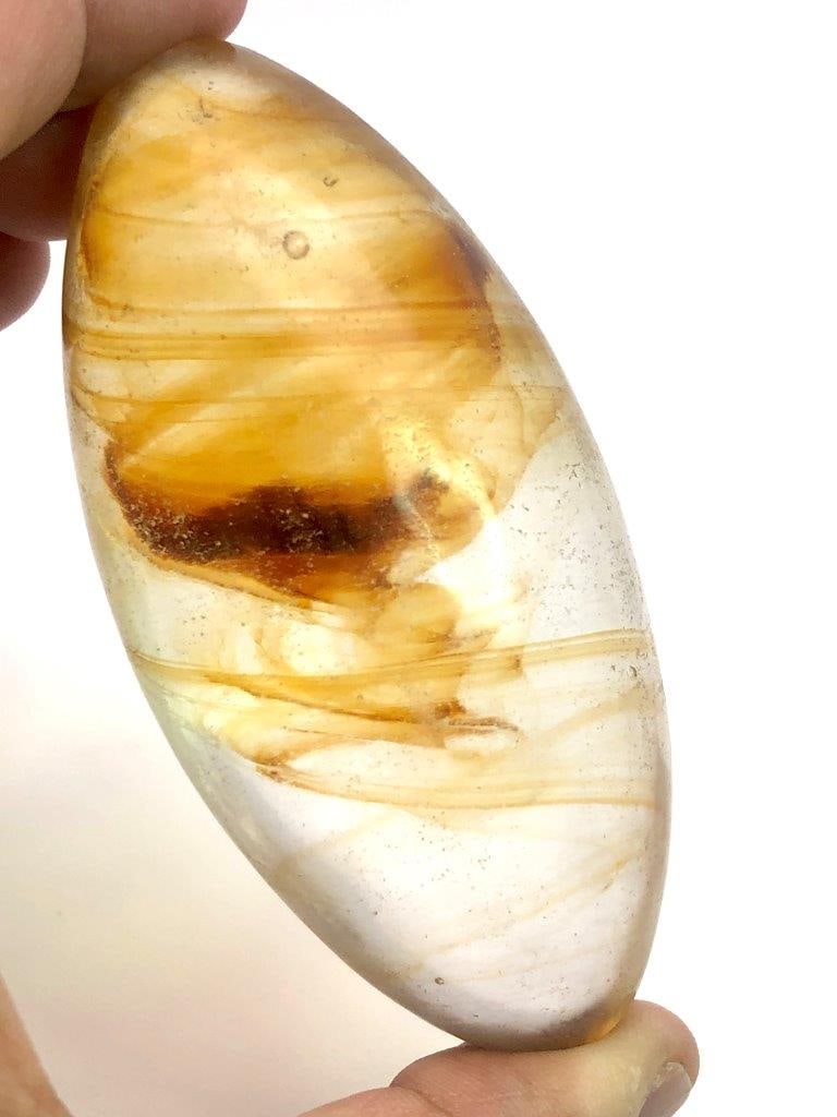 Carved Natural Glass Egg with Golden Inclusions – 129 g Decorative Mineral Specimen: This beautiful hand-carved natural glass egg weighs 129 grams and features striking golden inclusions suspended inside the translucent glass. The smooth egg shape highlights the natural internal patte